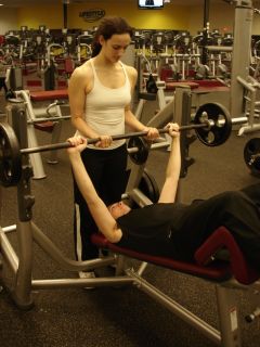 man doing decline barbell press with woman as spotter starting position