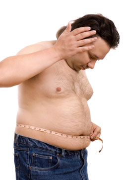 overweight man measuring his waist