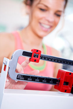 woman weighing herself on doctor's scale