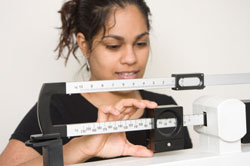 woman weighing self on doctor's scale