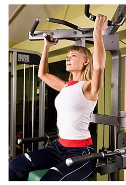 blond woman using exercise machine
