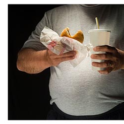 overweight man eating fast food