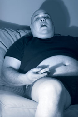 overweight man stuporous in front of television