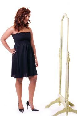 woman looking in full-length mirror